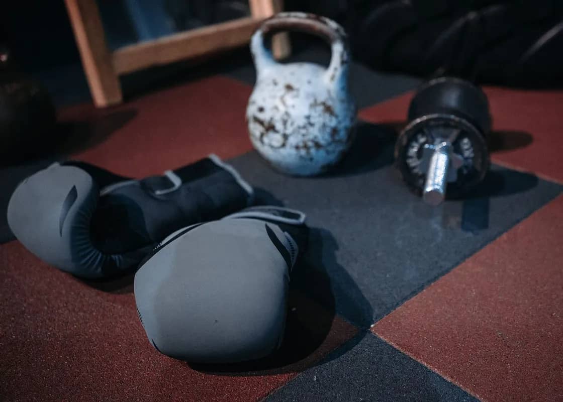 Kettlebell, dumbbells and gloves on a workout mat